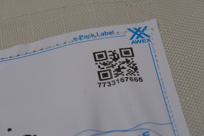 A black and white QR code on a white label 