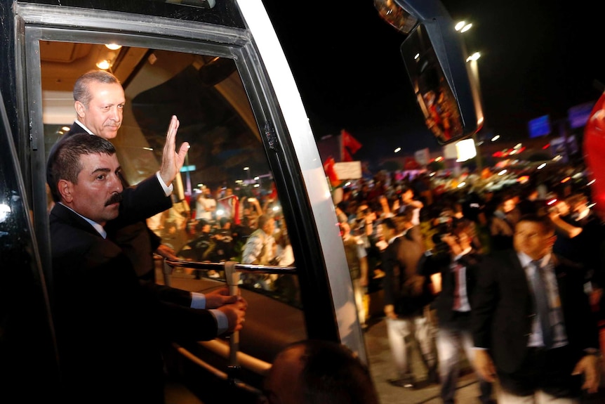 Tayyip Erdogan waves to supporters after arriving in Istanbul.