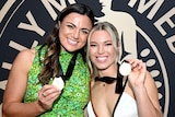 NRLW players Millie Boyle and Emma Tonegato show off their Dally M Medals.