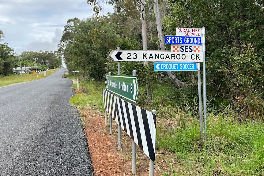 A road side sign on a tree-lined rural road saying 'Kangaroo Creek'