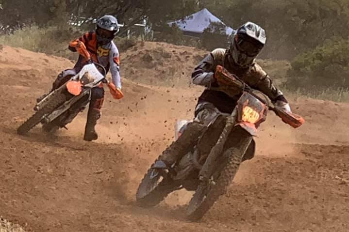 Two motorbike riders on a dirt track