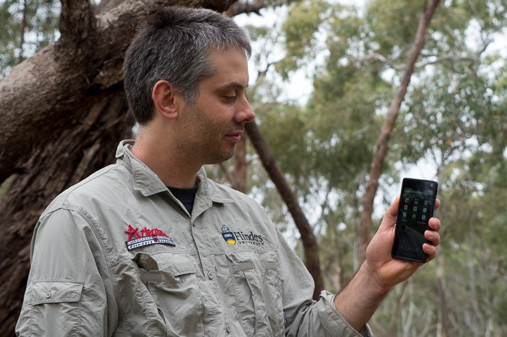 App creator Dr Paul Gardner-Stephen holding mobile phone.