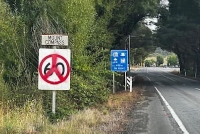 Una señal de límite de velocidad cubierta con un signo de la paz con pintura roja