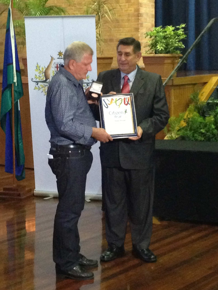 Flood volunteer Robert Brough (L) receives a Citizen of the Year award from Bundaberg Mayor Mal Forman.