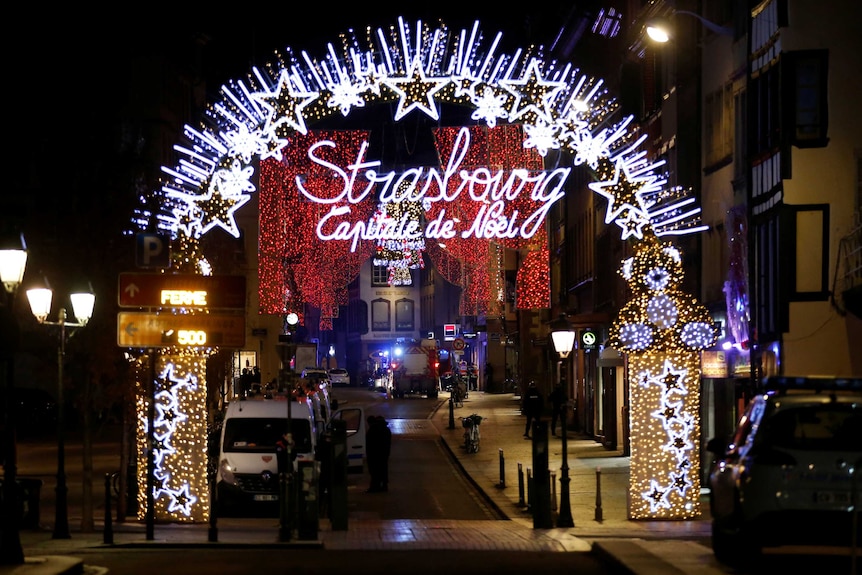 Rescue teams work on a street surrounded by Christmas decorations.