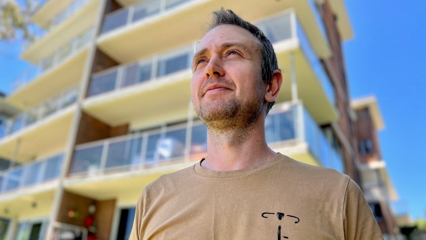 Aaron Doull stands in front of his apartment block 