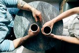 Aerial shot of couple at table holding a coffee each for a story about mental health struggles and relationships.