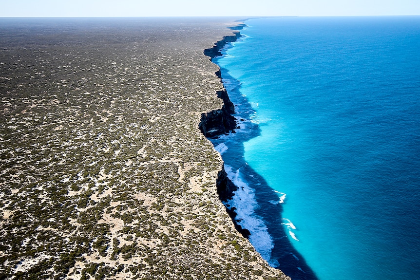 An aerial shot of cliffs next to the ocean.