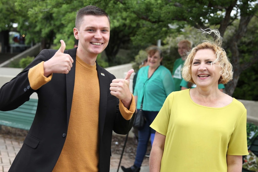 A man and a woman smile at the camera.