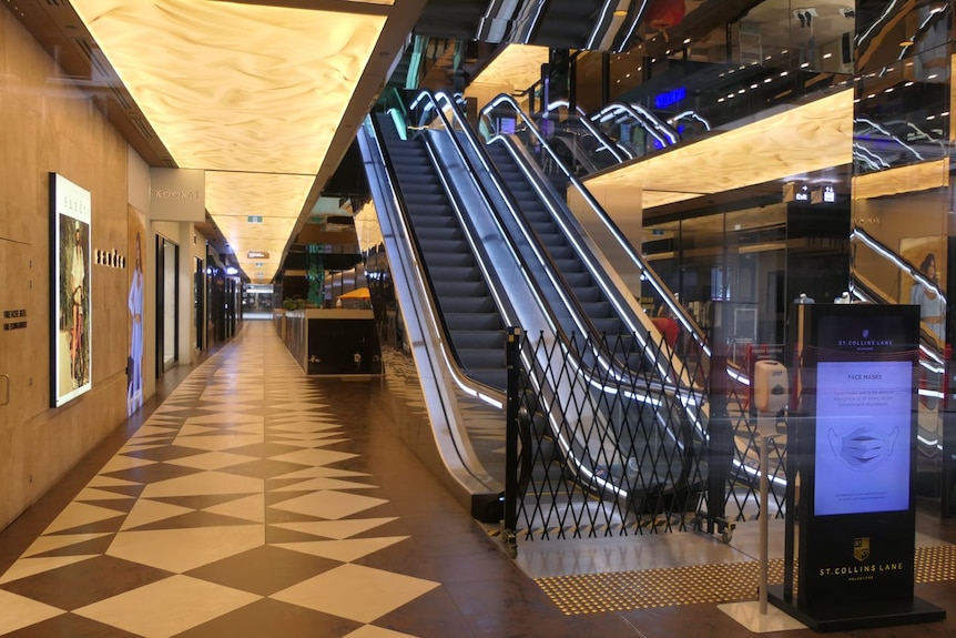 The interior of a shopping centre with two escalators blocked off.