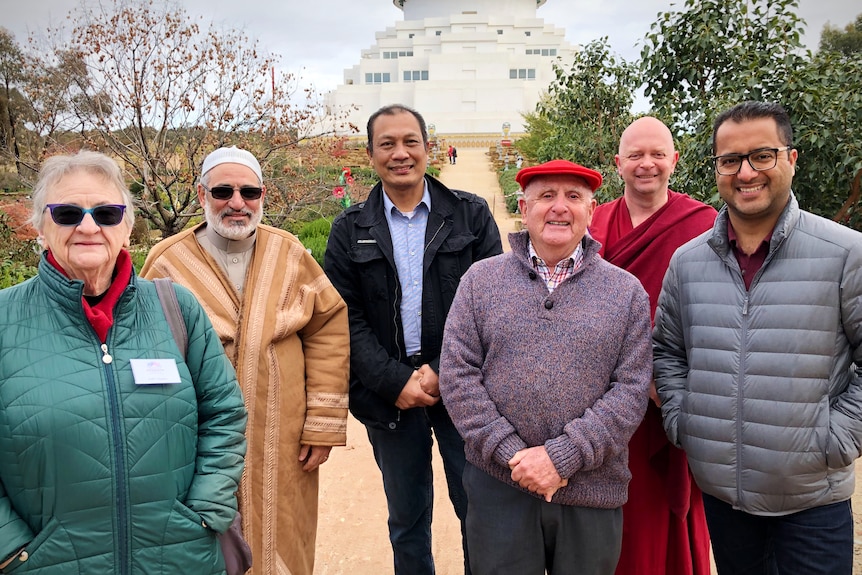 a group of religious and cultural leaders stand for a photo