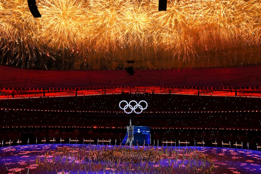 The Olympic rings are seen inside the Bird's Nest stadium in Beijing as a rush of golden fireworks explode overhead.