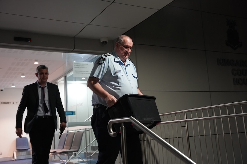 A police officer carrying a box