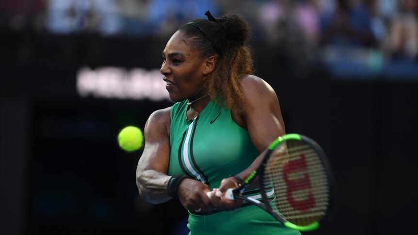 Serena Williams grimaces as she plays a double handed backhand.