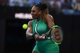 Serena Williams grimaces as she plays a double handed backhand.