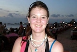 Leisl Smith, a young woman with dark hair, smiles into the camera, wearing a singlet top.