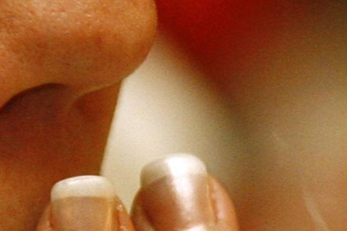 Close up of a woman smoking a cigarette in a restaurant.