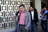 Greek finance minister Euclid Tsakalotos (C) leaves a hotel following an overnight meeting with his EU counterparts
