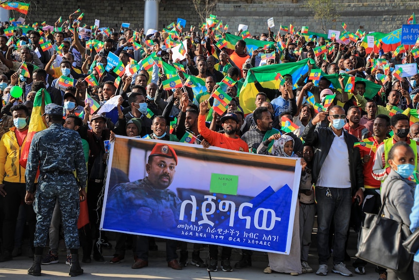 A group of government supporters hold up sign with a picture of Prime Minister Abiy Ahmed. 