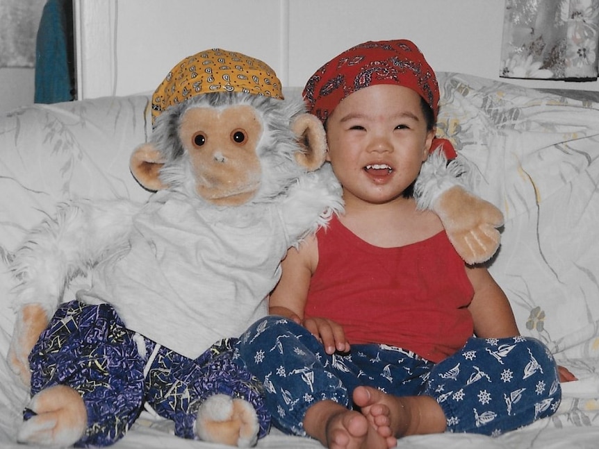 Baby Jordy dressed in a white and blue baby outfit on a blue mat