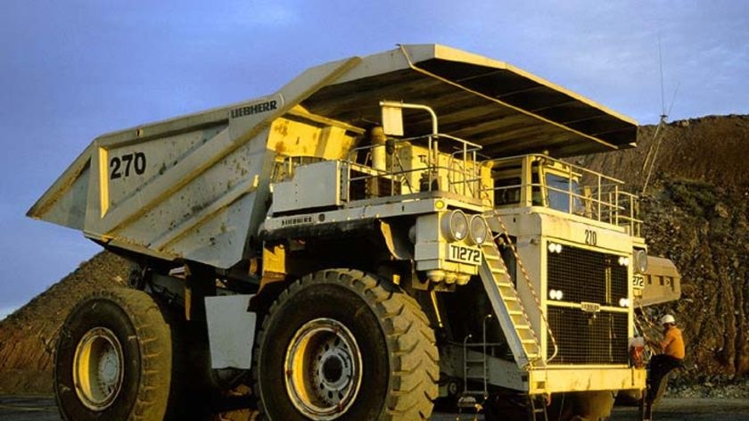 A mine worker climbs onto a mining truck at the Superpit in Kalgoorlie, Western Australia
