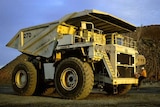 A mine worker climbs onto a mining truck at the Superpit in Kalgoorlie, Western Australia