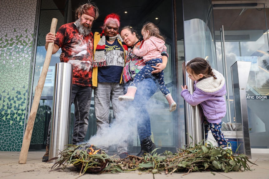 A group of people conduct a smoking ceremony