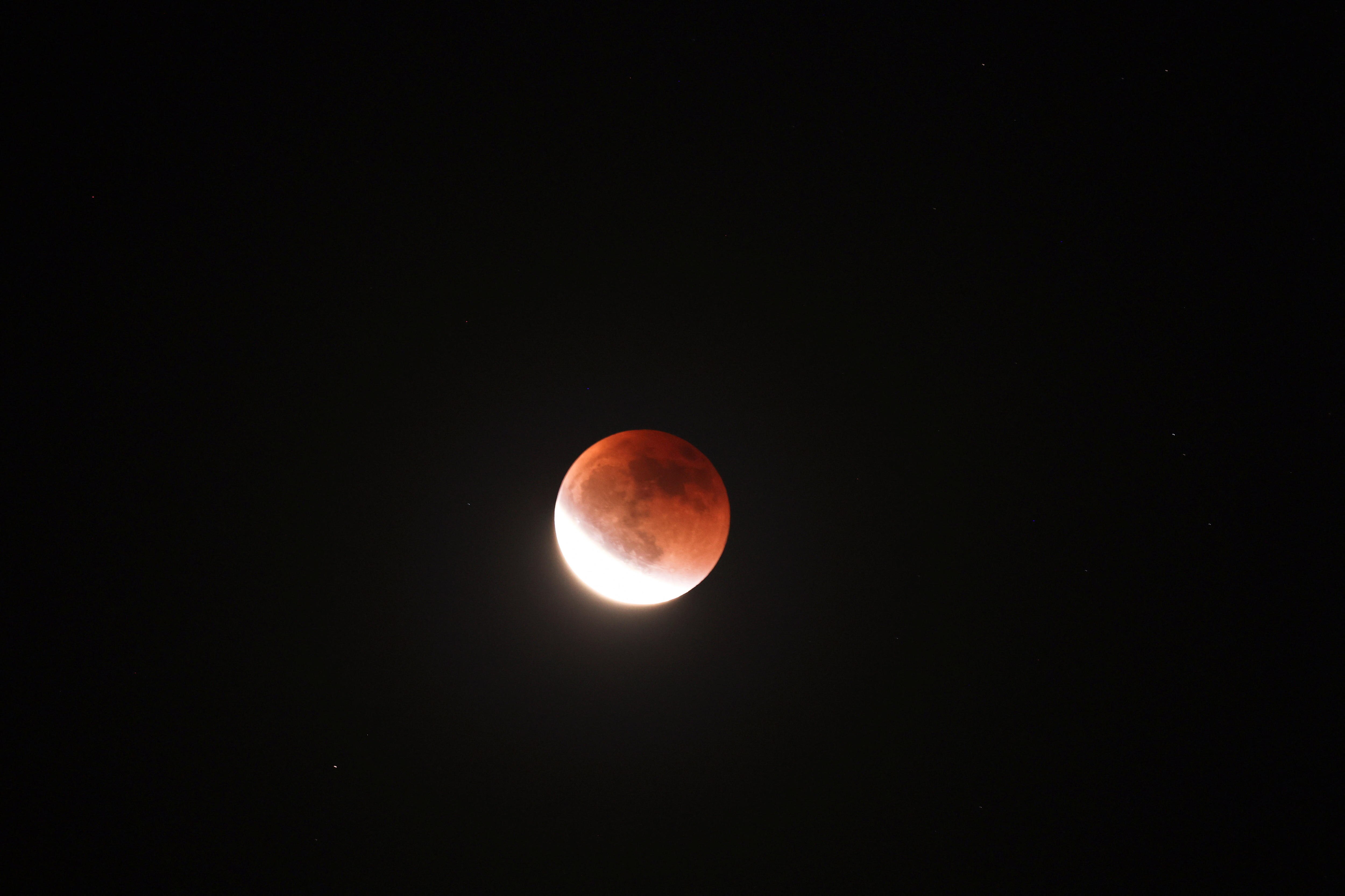 A partial blood moon eclipse is seen in the night sky