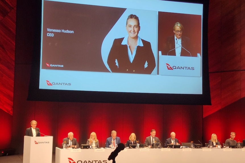 Qantas CEO Vanessa Hudson speaks at the company's 2023 AGM, with the board members sitting next to her.