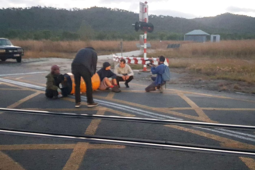 French journalist Hugo Clement talks to protesters, with photographers, outside Abbot Point coal terminal near Bowen.