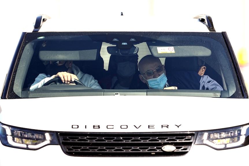 two men in a large white car