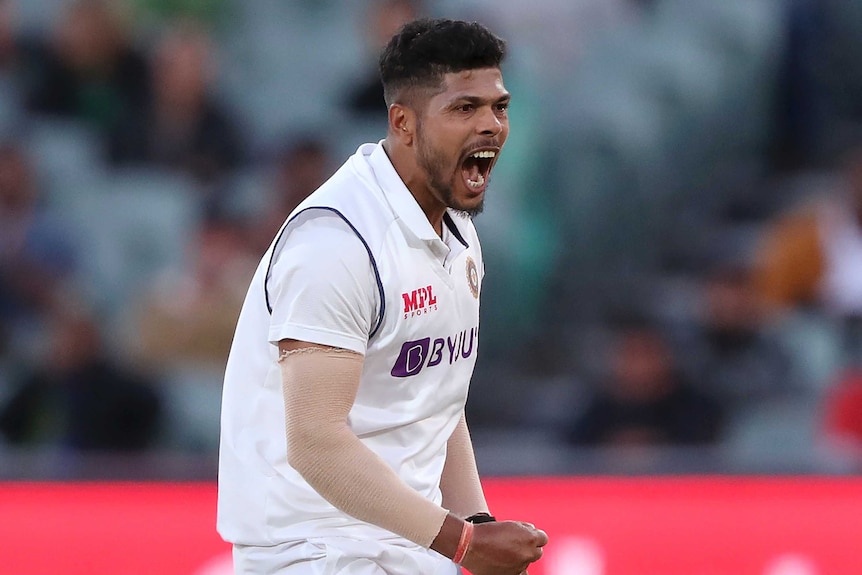 UMesh Yadav clenches his fists and yells with a wide open mouth