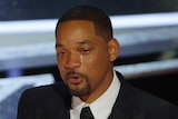 A tightly cropped portrait of will smith's face. he is crying while speaking