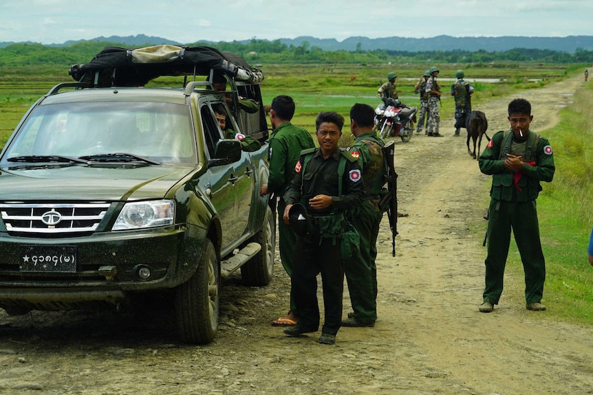 The army (front) and the Border Guard Police (rear), gather on a dirt path in Myanmar