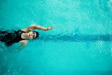 View from directly above a woman training in a pool for competitive swimming.