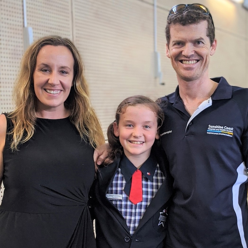 Girl and her parents at a school event.