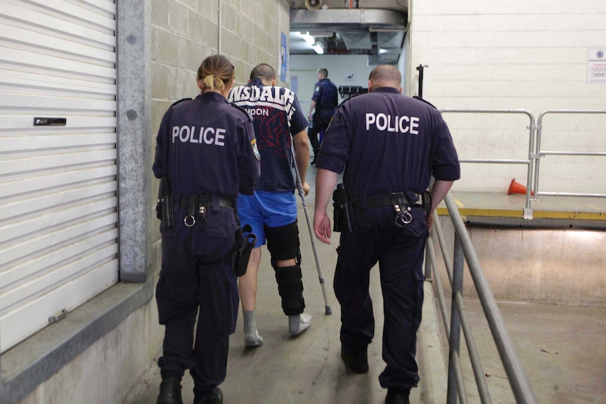 A member of Brothers 4 Life enters a police station after being arrested in Auburn.