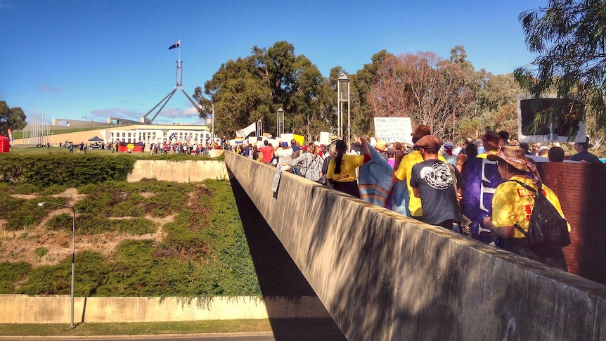March in March protesters walk towards Parliament House in Canberra.
