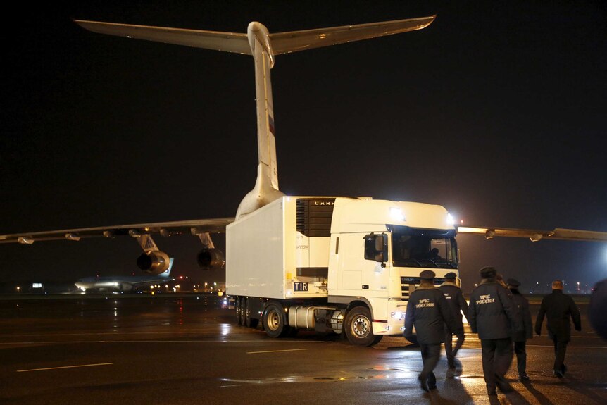 Russian officials walk to the truck near the airplane.