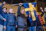 Protesters burn the national flag of Sweden as they demonstrate.