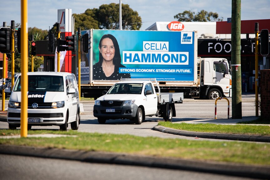 A truck drives past other cars, with the words Celia Hammond and a picture of a woman on the side.