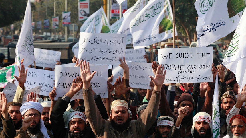 People in Lahore hold signs as they chant slogans during a protest against satirical French weekly newspaper Charlie Hebdo