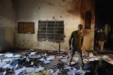 A Pakistani soldier walks amidst the debris in an army-run school