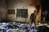 A Pakistani soldier walks among the debris in the Peshawar school.