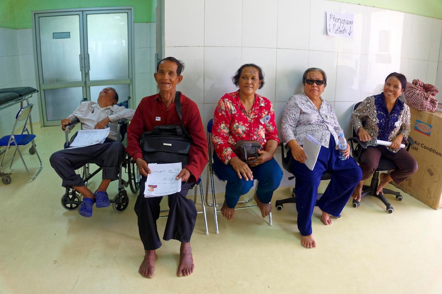 Cambodian patients sit in a makeshift waiting room