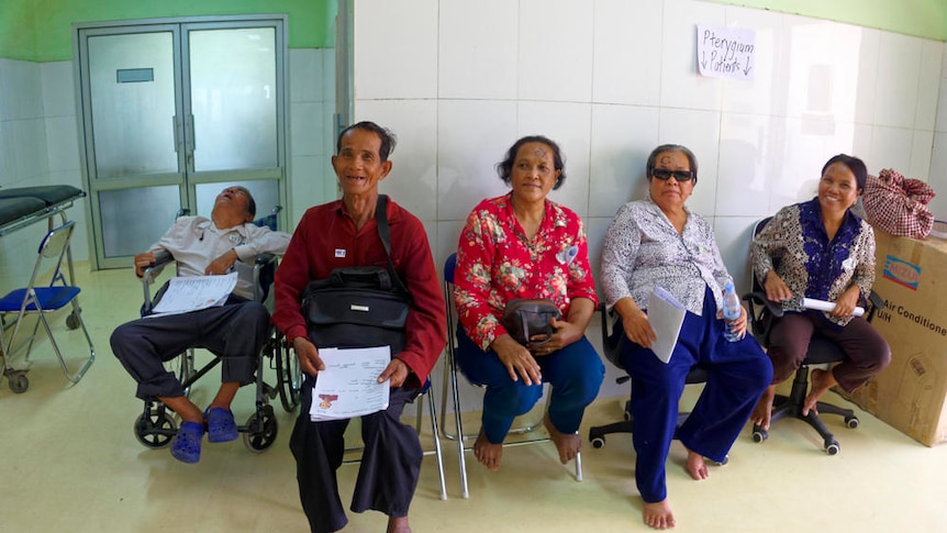 Cambodian patients sit in a makeshift waiting room