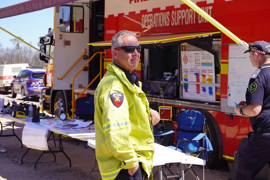 QFES Incident Controller Paul Smeath stands in front of a fire truck
