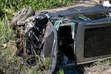 A vehicle rests on its side along a road after a rollover accident involving golfer Tiger Woods.