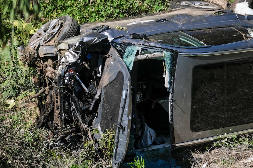 A vehicle rests on its side along a road after a rollover accident involving golfer Tiger Woods.