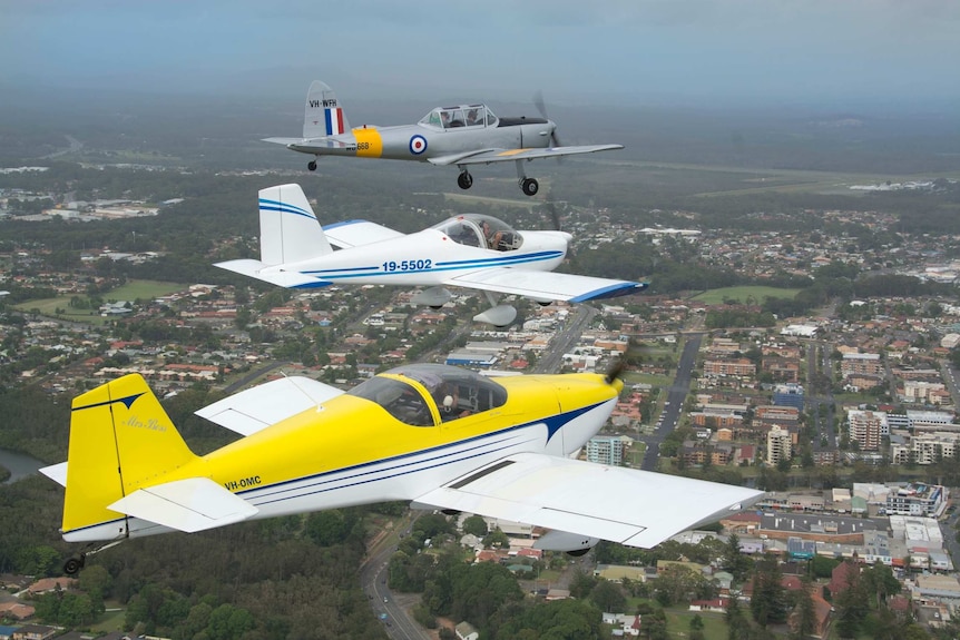 Dr Cooke's vintage plane flying in a Bobcat formation over Port Macquarie